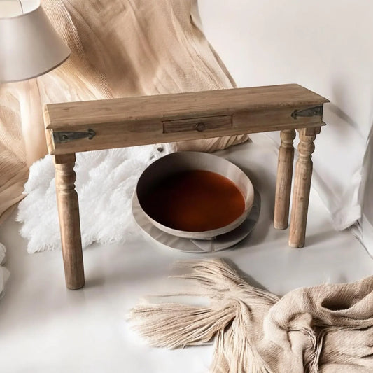 Rustic wooden console table with turned legs, styled with neutral throw and decorative bowls, Bert Joseph furniture.