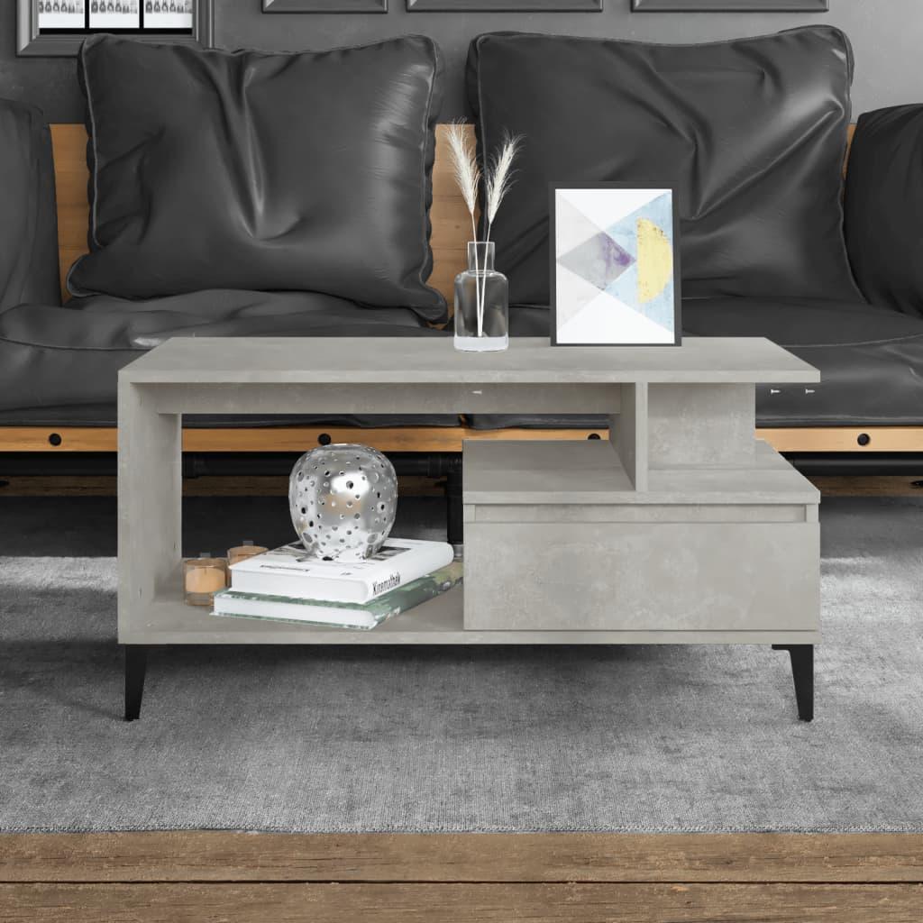Modern concrete-effect coffee table with open shelf and drawer, styled in a contemporary living room with black leather cushions.
