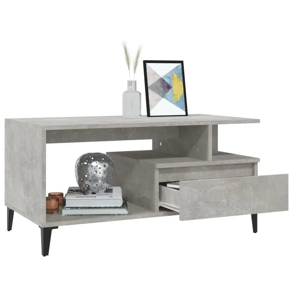 Modern grey concrete-effect coffee table with open shelf, drawer, and black legs, styled with decor.