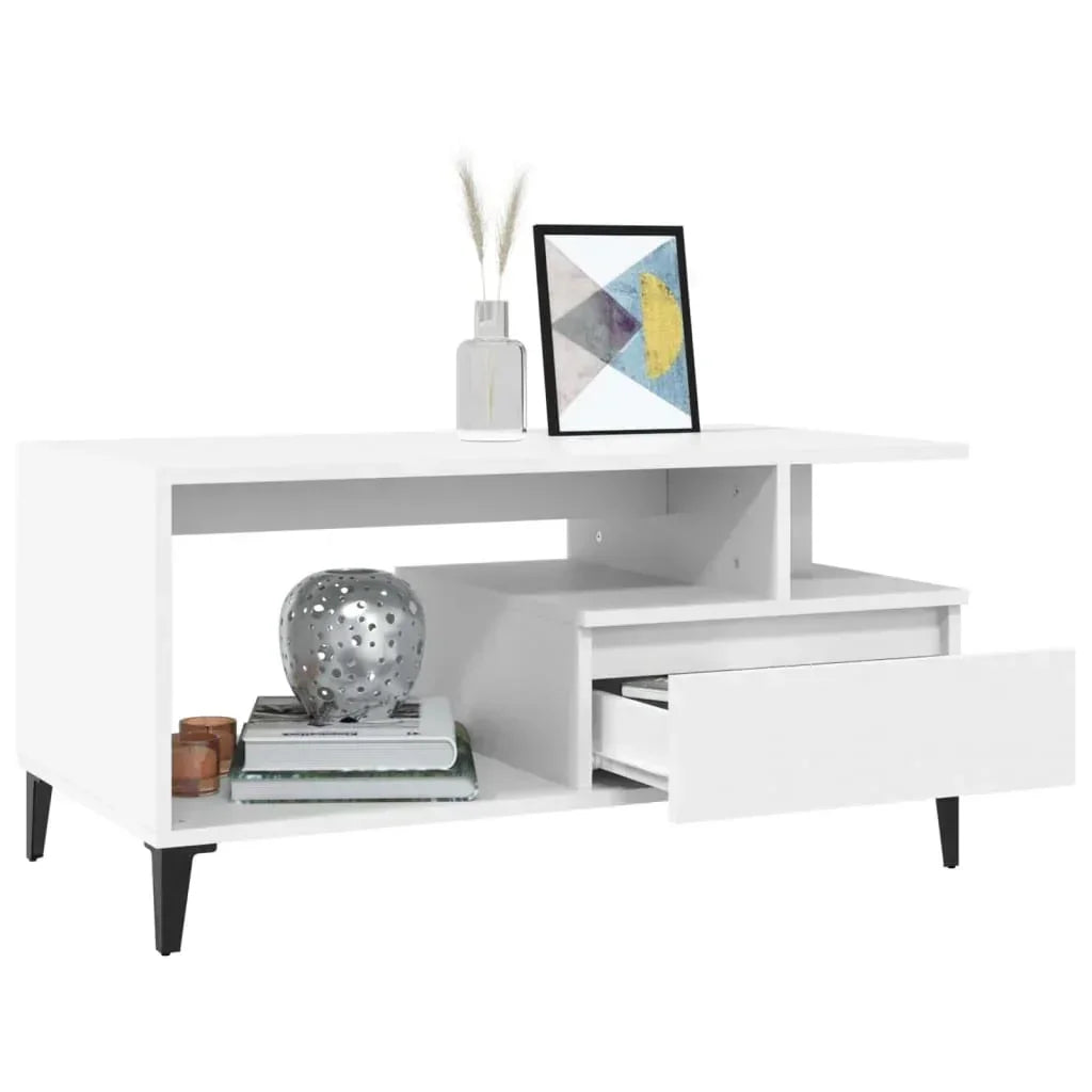Modern white TV unit with black legs, open shelves, and drawer, styled with decor accents